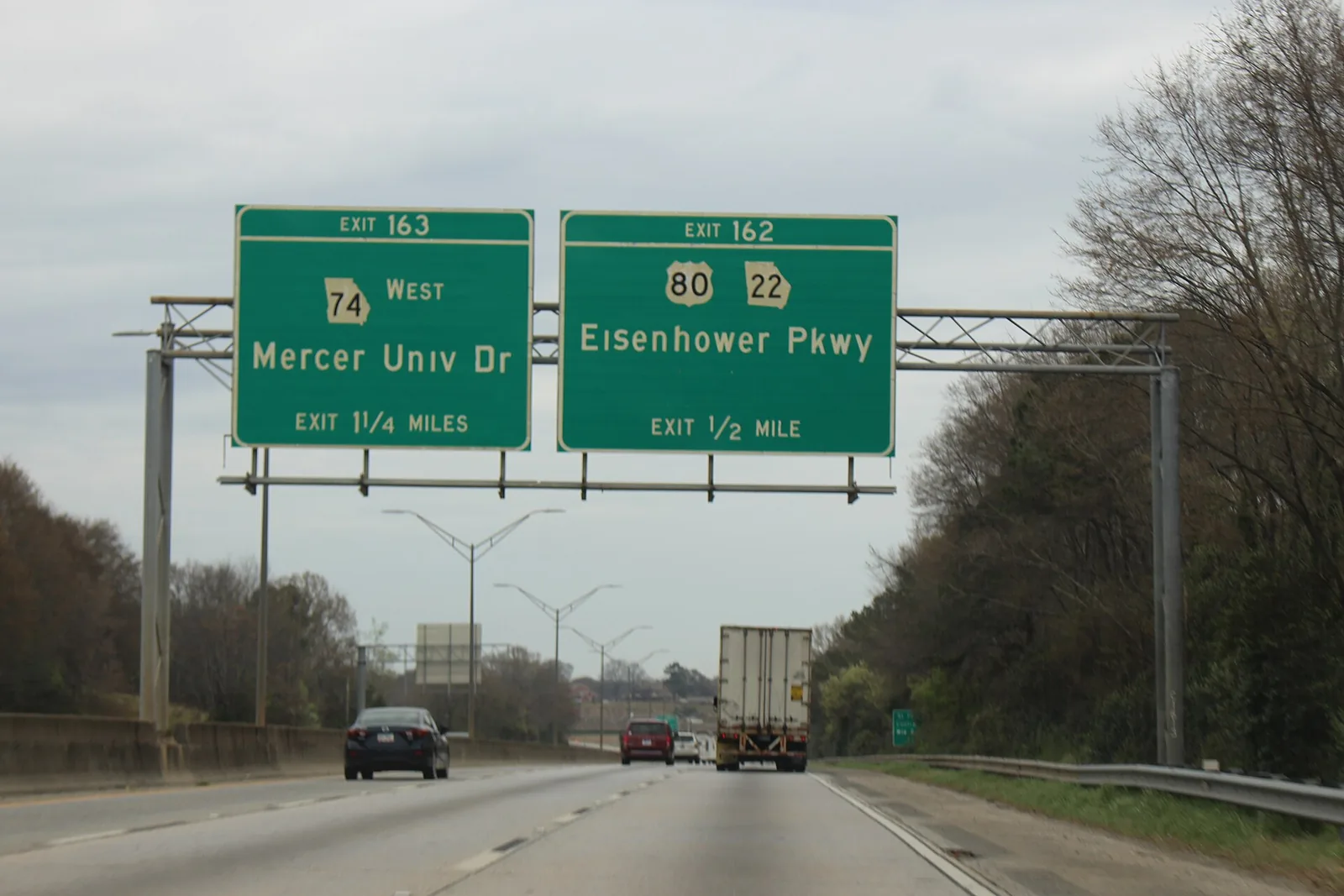 Northbound Interstate 75 in Macon, Georgia, with green overhead exit signs for Mercer University Drive and Eisenhower Parkway and a tractor-trailer ahead