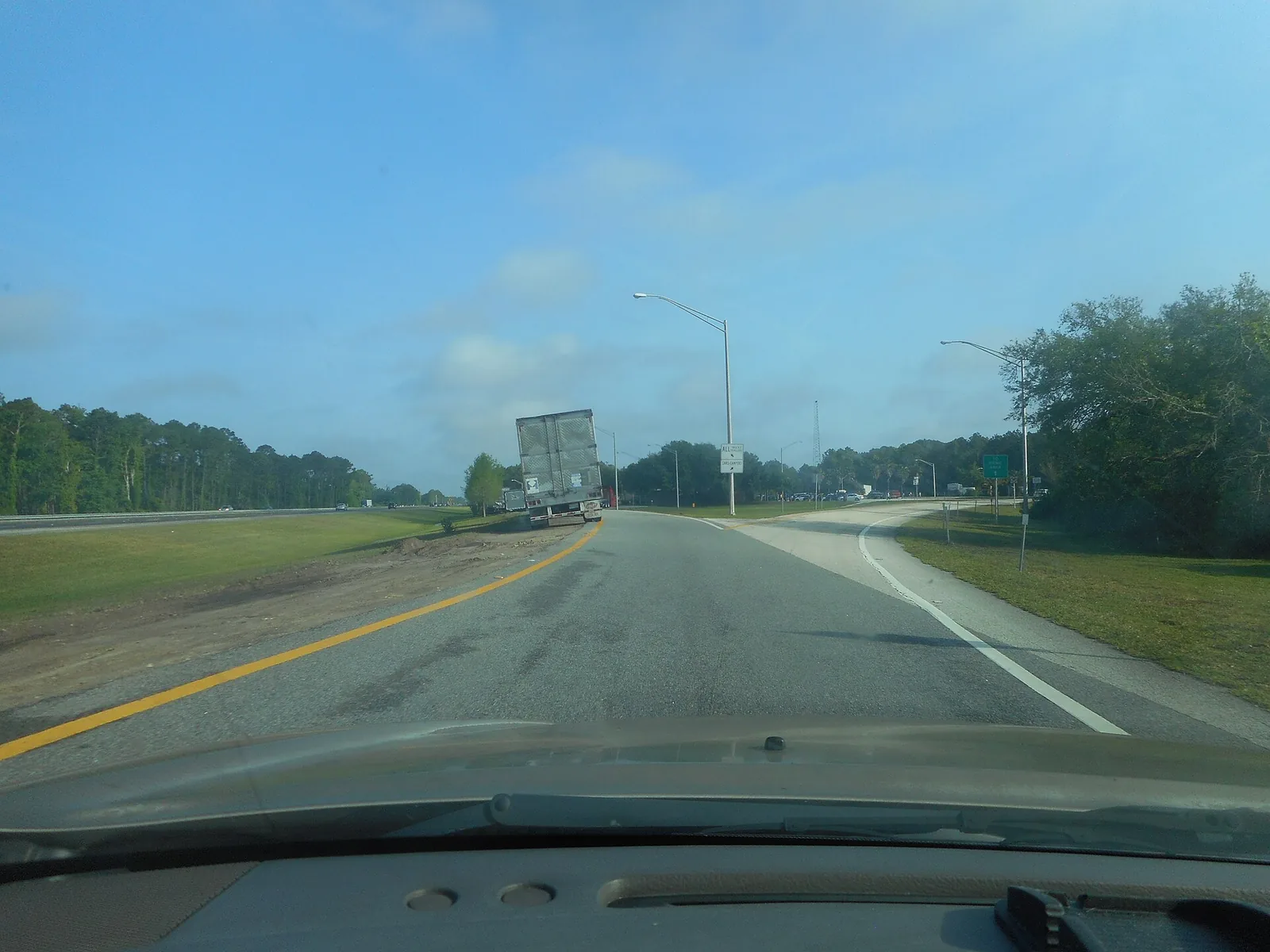 The split between the truck parking lane and the car parking lane at the northbound I-95 rest area in St. Johns County, Florida, with a trailer parked on the truck side